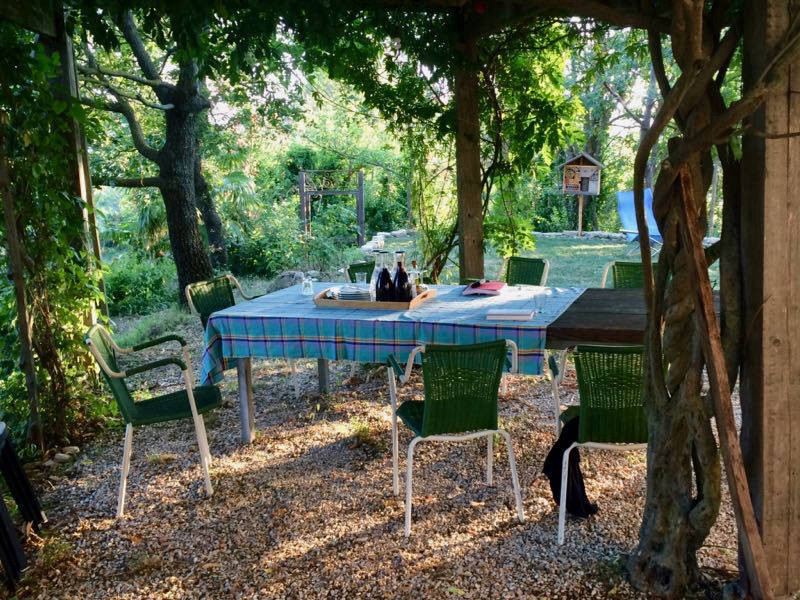 Esstisch im Schatten der Pergola